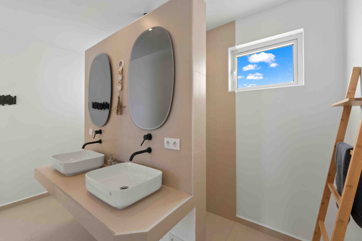 Ensuite badkamer van de master slaapkamer met dubbele wastafel en inloopdouche