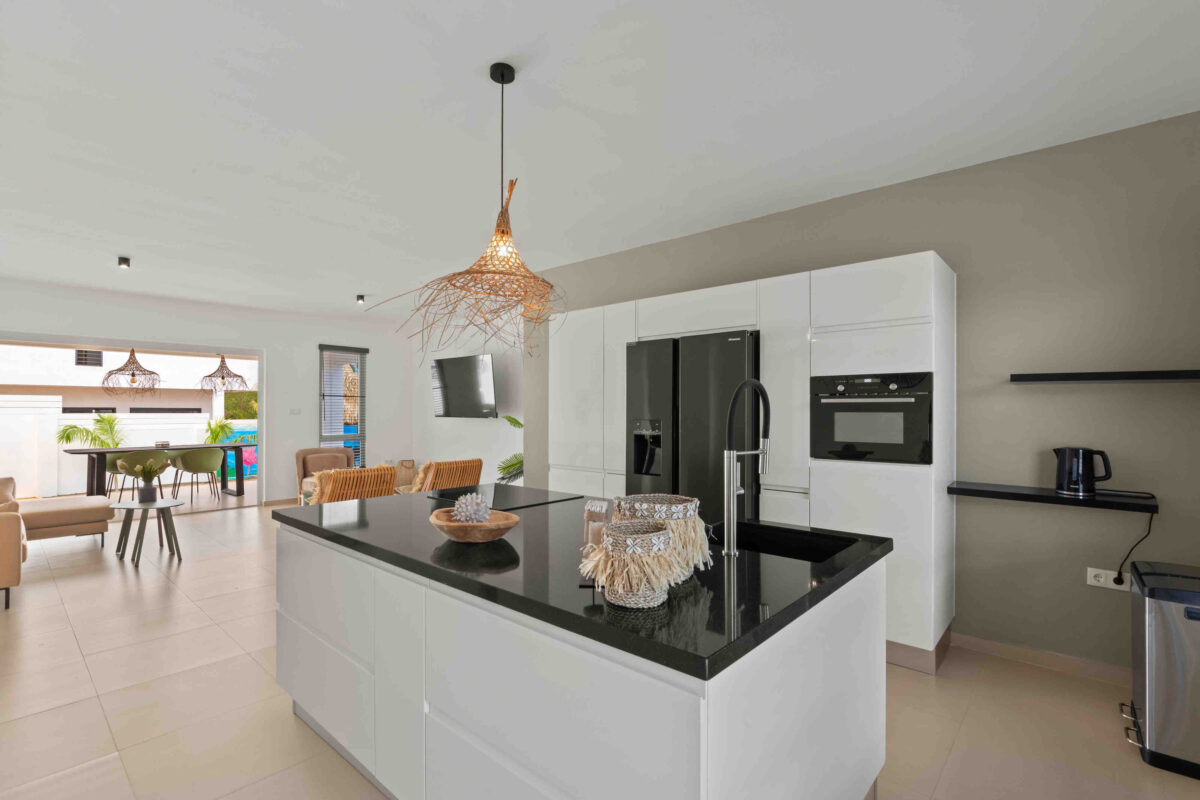 Moderne open keuken met kookeiland en uitzicht op woonkamer en terras