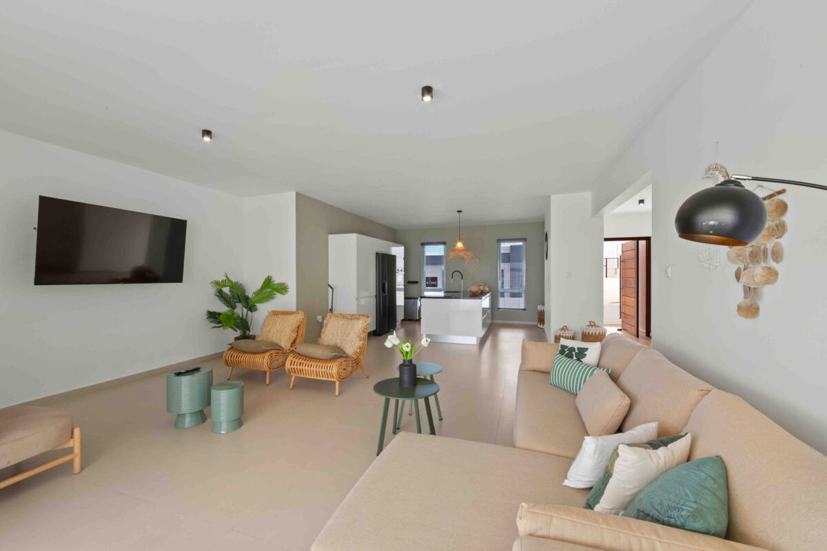Ruime woonkamer met zithoek en open keuken in vakantiehuis Curaçao