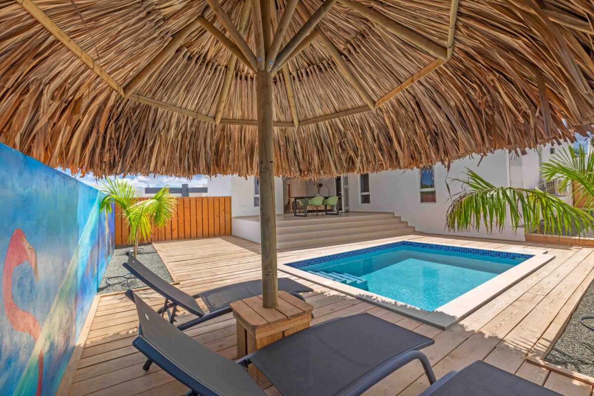Privézwembad Curaçao onder palapa met ligstoelen en tropische sfeer